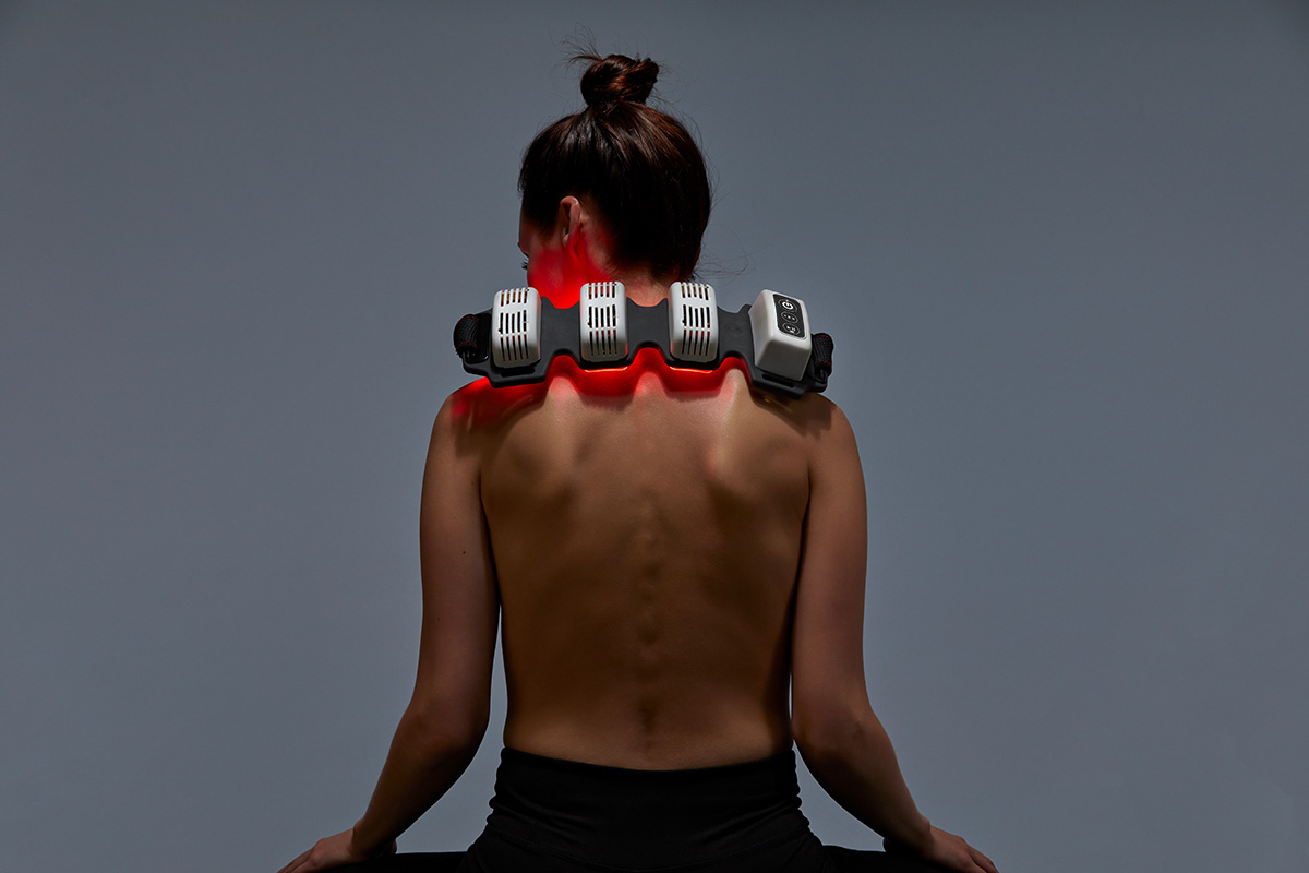 Woman wearing FlexBeam red light therapy device